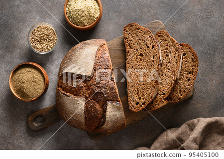 Loaf of gluten-free bread with hemp flour on brown background. Artisan bread. View from above. 95405100