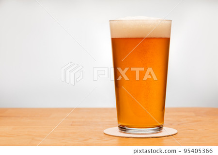 Full shaker pint glass of ale or beer on a table Full shaker pint glass of ale or beer on a table 95405366