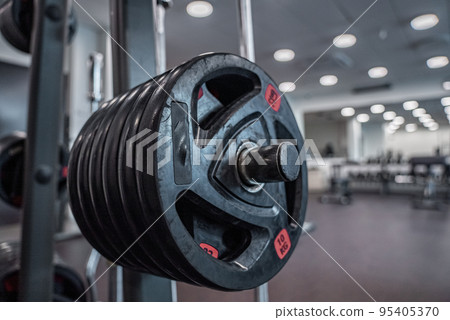 Modern light gym. Sports equipment in gym. Barbells of different weight on rack. Modern light gym. Sports equipment in gym. Barbells of different weight on rack. 95405370