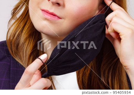 Woman releasing her face mask Woman releasing her face mask 95405934