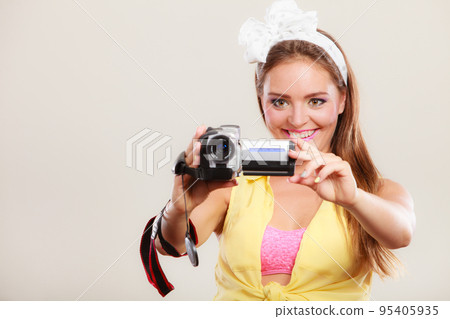 Happy pin up girl woman filming with camcorder. 95405935