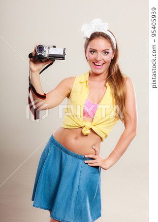 Happy pin up girl woman filming with camcorder. 95405939