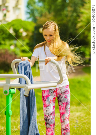 Female doing exercise in outdoor gym Female doing exercise in outdoor gym 95406875