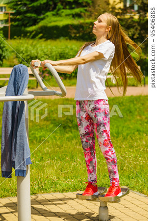 Female doing exercise in outdoor gym Female doing exercise in outdoor gym 95406888