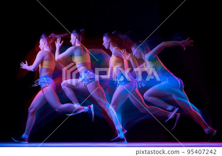 Development of movements. Professional female athlete, runner in motion over dark background in mixed neon light. Art, beauty, sport, cyberpunk concept Development of movements. Professional female athlete, runner in motion over dark background in mixed neon light. Art, beauty, sport, cyberpunk concept 95407242