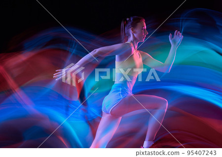 Glow. Professional female athlete, runner in motion over dark background in mixed neon light. Art, beauty, sport, cyberpunk concept 95407243