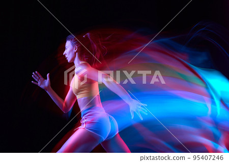 Energy. Professional female athlete, runner in motion over dark background in mixed neon light. Art, beauty, sport, cyberpunk concept 95407246