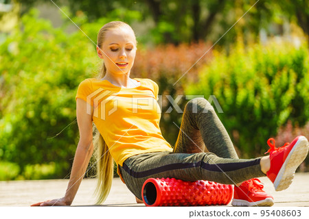 Girl doing exercises outdoor, using roller Girl doing exercises outdoor, using roller 95408603