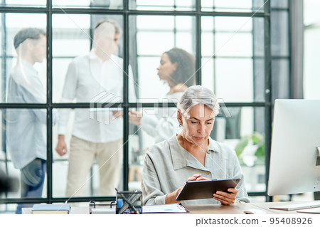 businesswoman with a clipboard sitting at a desk . businesswoman with a clipboard sitting at a desk . 95408926