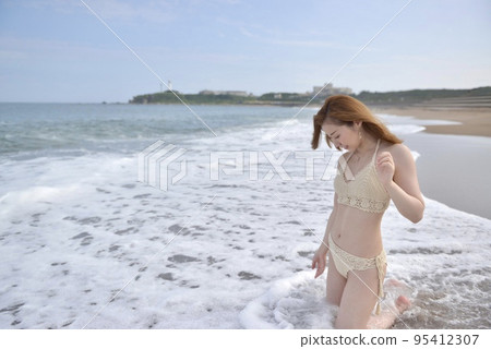 Young woman wearing a bikini swimsuit on the beach 95412307