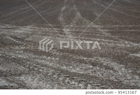 Agriculture. Tractor cultivated land. A field with traces of wheeled vehicles in early spring for sowing cereals. 95413167