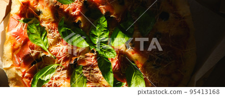 Appetizing delicious pizza. Close-up view of a piece of pizza with dark shadows. Food delivery. Pizza close up. 95413168