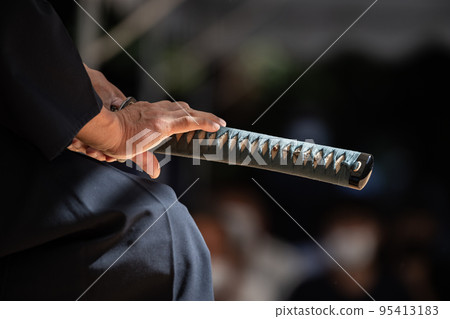 A person holding a Japanese sword A person holding a Japanese sword 95413183