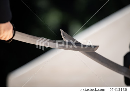 A person holding a Japanese sword A person holding a Japanese sword 95413186
