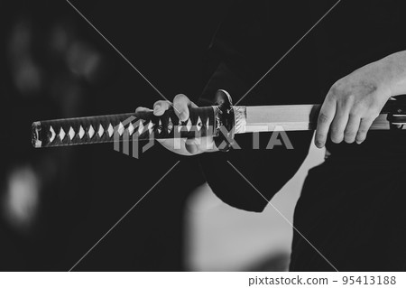 A person holding a Japanese sword A person holding a Japanese sword 95413188