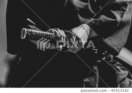 A person holding a Japanese sword A person holding a Japanese sword 95413192