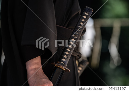 A person holding a Japanese sword A person holding a Japanese sword 95413197