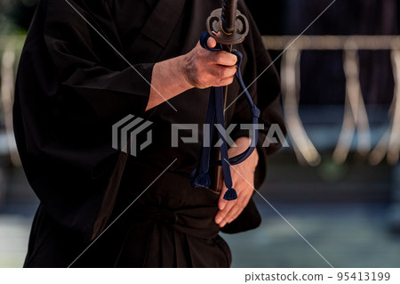 A person holding a Japanese sword A person holding a Japanese sword 95413199