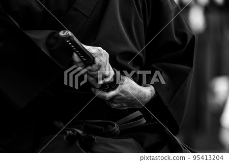 A person holding a Japanese sword 95413204