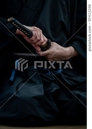 A person holding a Japanese sword A person holding a Japanese sword 95413206