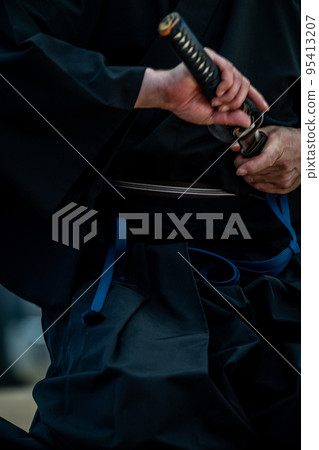 A person holding a Japanese sword A person holding a Japanese sword 95413207
