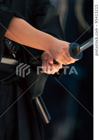 A person holding a Japanese sword A person holding a Japanese sword 95413215