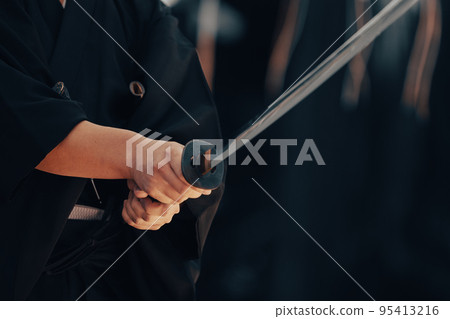 A person holding a Japanese sword A person holding a Japanese sword 95413216