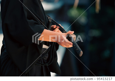 A person holding a Japanese sword 95413217