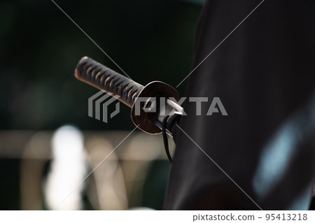 A person holding a Japanese sword A person holding a Japanese sword 95413218