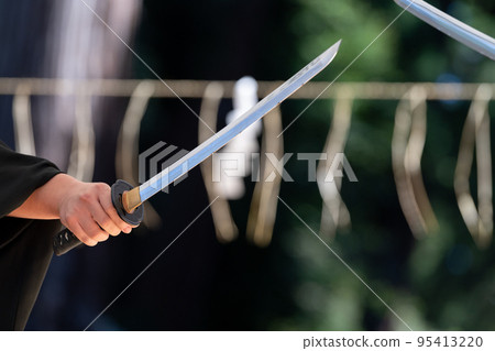 A person holding a Japanese sword A person holding a Japanese sword 95413220