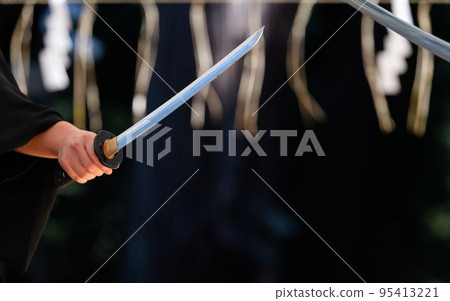 A person holding a Japanese sword A person holding a Japanese sword 95413221
