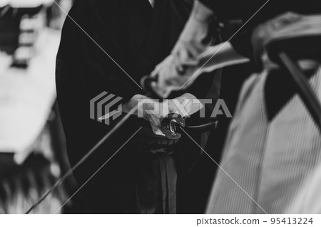 A person holding a Japanese sword A person holding a Japanese sword 95413224
