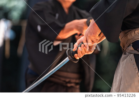 A person holding a Japanese sword A person holding a Japanese sword 95413226