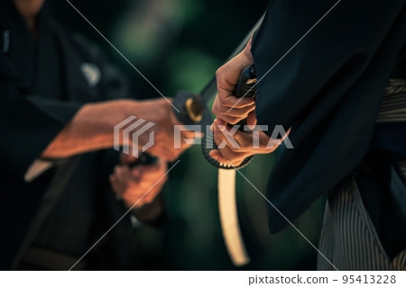 A person holding a Japanese sword A person holding a Japanese sword 95413228