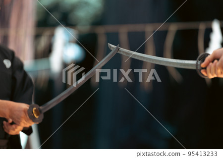 A person holding a Japanese sword A person holding a Japanese sword 95413233