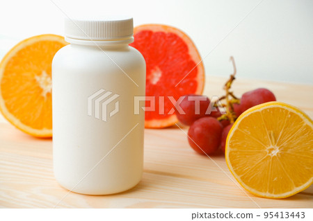 Vitamins. White empty bottle for vitamins on a background of citrus fruit slices. lemon. orange. White background. Blank Medicine bottle Vitamins. White empty bottle for vitamins on a background of citrus fruit slices. lemon. orange. White background. Blank Medicine bottle 95413443