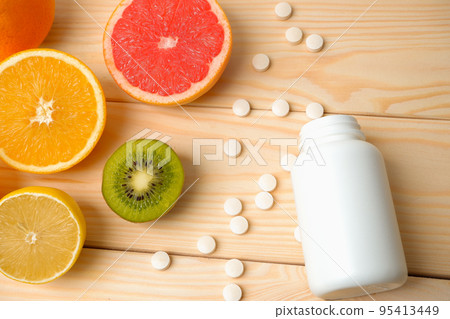 Vitamins. Medical concept. Pharmacy or natural. White bottle with vitamins, scattered pills. Juicy ripe citrus fruit slices. lemon. Orange. Grapefruit. Vitamins. Medical concept. Pharmacy or natural. White bottle with vitamins, scattered pills. Juicy ripe citrus fruit slices. lemon. Orange. Grapefruit. 95413449