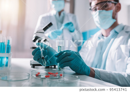 Doctor in the laboratory analyzes samples of codiv-9 under a microscope Doctor in the laboratory analyzes samples of codiv-9 under a microscope 95413741