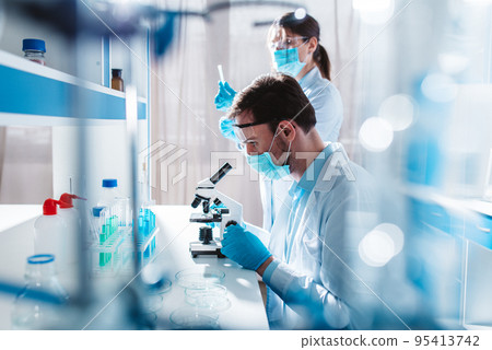 Doctor in the laboratory analyzes samples of codiv-9 under a microscope Doctor in the laboratory analyzes samples of codiv-9 under a microscope 95413742