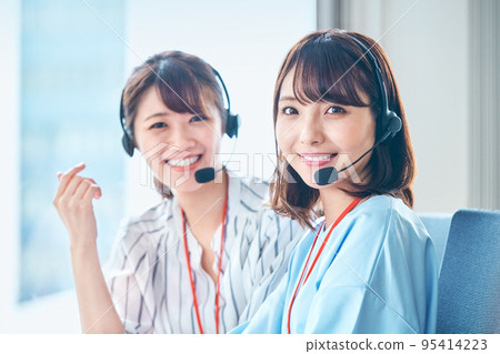 A young female operator looking at a camera working in a call center 95414223