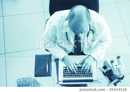 science lab technician using a laptop during his research. 95414526