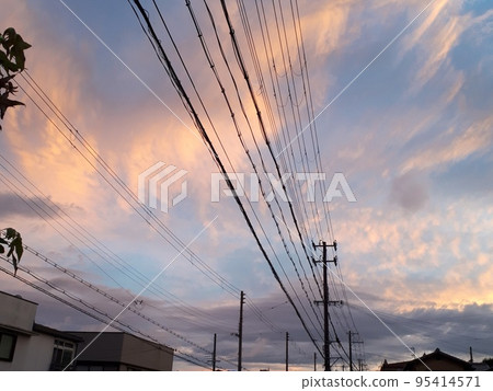 Electric poles and electric wires seen against the background of the evening sky dyed red 95414571