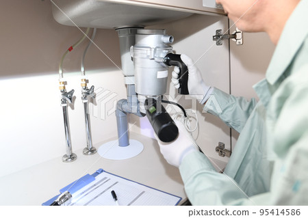 Male worker installing a disposer Male worker installing a disposer 95414586