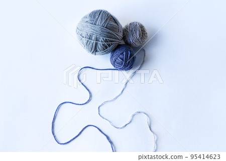 Three blue knitted wool on a blue background for knitting warm clothes, hobbies Three blue knitted wool on a blue background for knitting warm clothes, hobbies 95414623