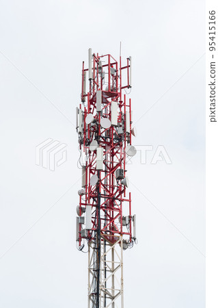 upper part of the radio tower with installed antennas and other equipment against a white cloudy sky 95415166