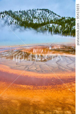 Winter at Yellowstone with stunning red and orange layers by steamy spring 95415655