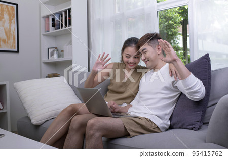 Asian couple using laptop to connect with family for video call Asian couple using laptop to connect with family for video call 95415762