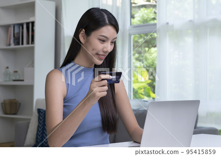 Asian woman holding credit card and using laptop. Online shopping, e-commerce, internet banking Asian woman holding credit card and using laptop. Online shopping, e-commerce, internet banking 95415859