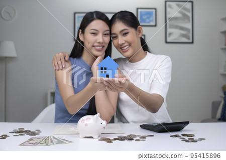 Asian lesbian couple saving money to buy a house.LGBT women couple saving money for family and home 95415896