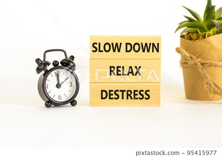 Destress symbol. Concept words Slow down Relax Destress on wooden block. Black alarm clock. Beautiful white table white background. Psychological business slow down Relax destress concept. Copy space. Destress symbol. Concept words Slow down Relax Destress on wooden block. Black alarm clock. Beautiful white table white background. Psychological business slow down Relax destress concept. Copy space. 95415977